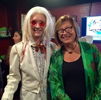 a woman in a white costume standing next to a man in a green suit